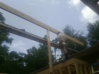Carpenter setting a ridge beam over a new addition frame — Ice Dam Removal by Roofing Brothers in Shambaugh