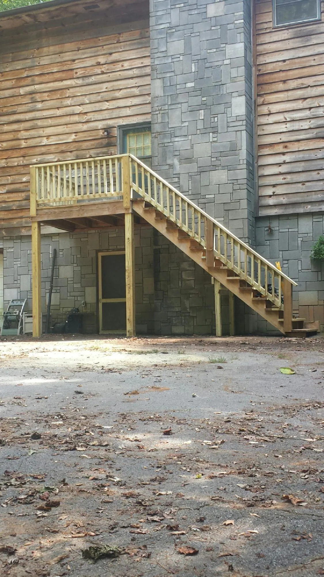 New pressure treated deck and stair landing on a log home in Shambaugh
