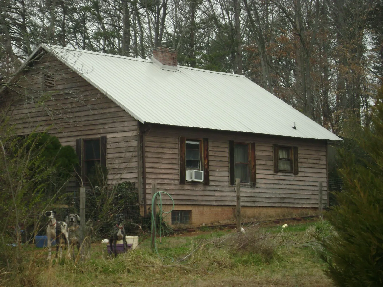 White metal roof on an old wood sided farmhouse, from a Metal Roof Installation job in Shambaugh